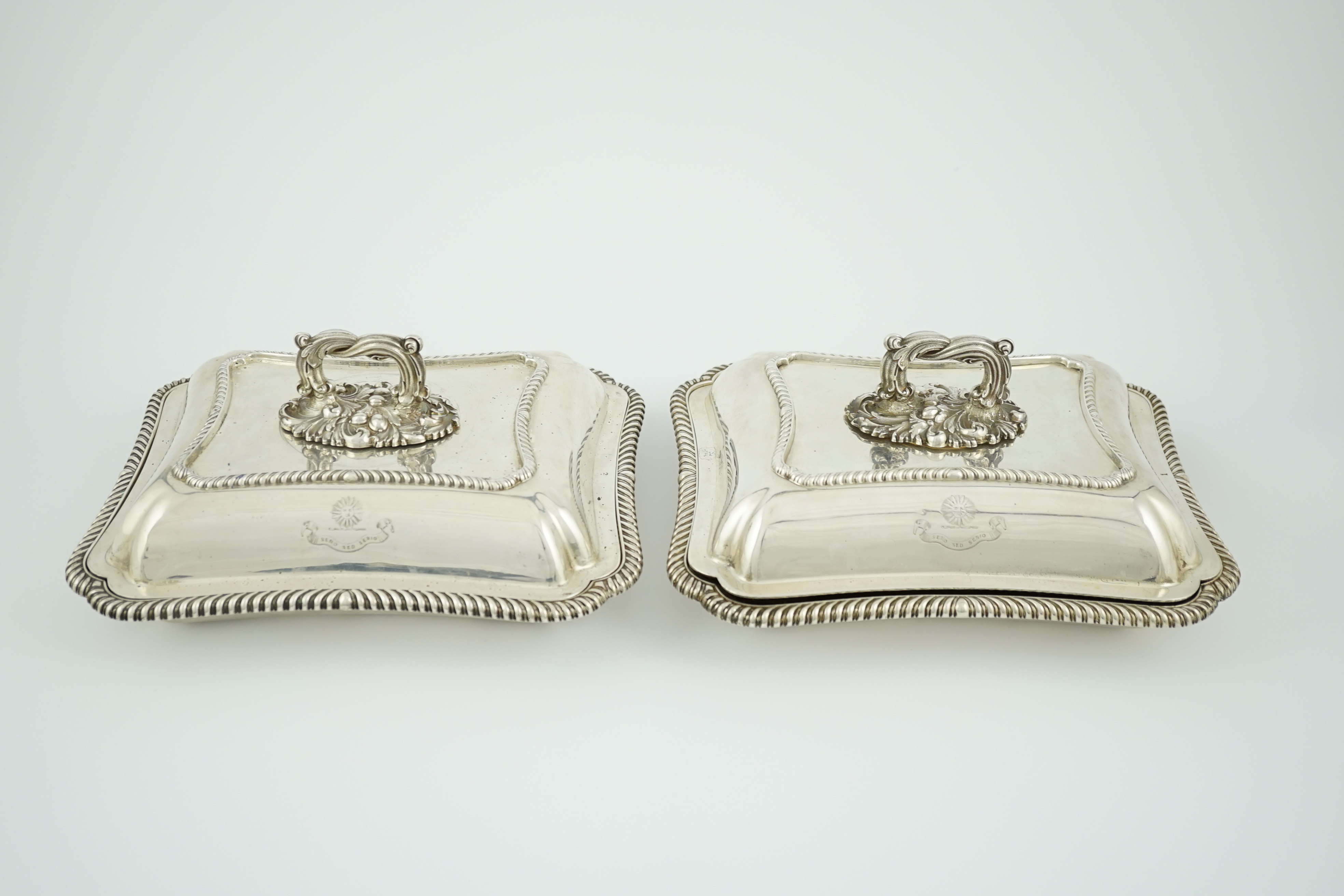 A pair of Edwardian silver shaped rectangular entrée dishes and covers with handles, by Goldsmiths & Silversmiths Co Ltd